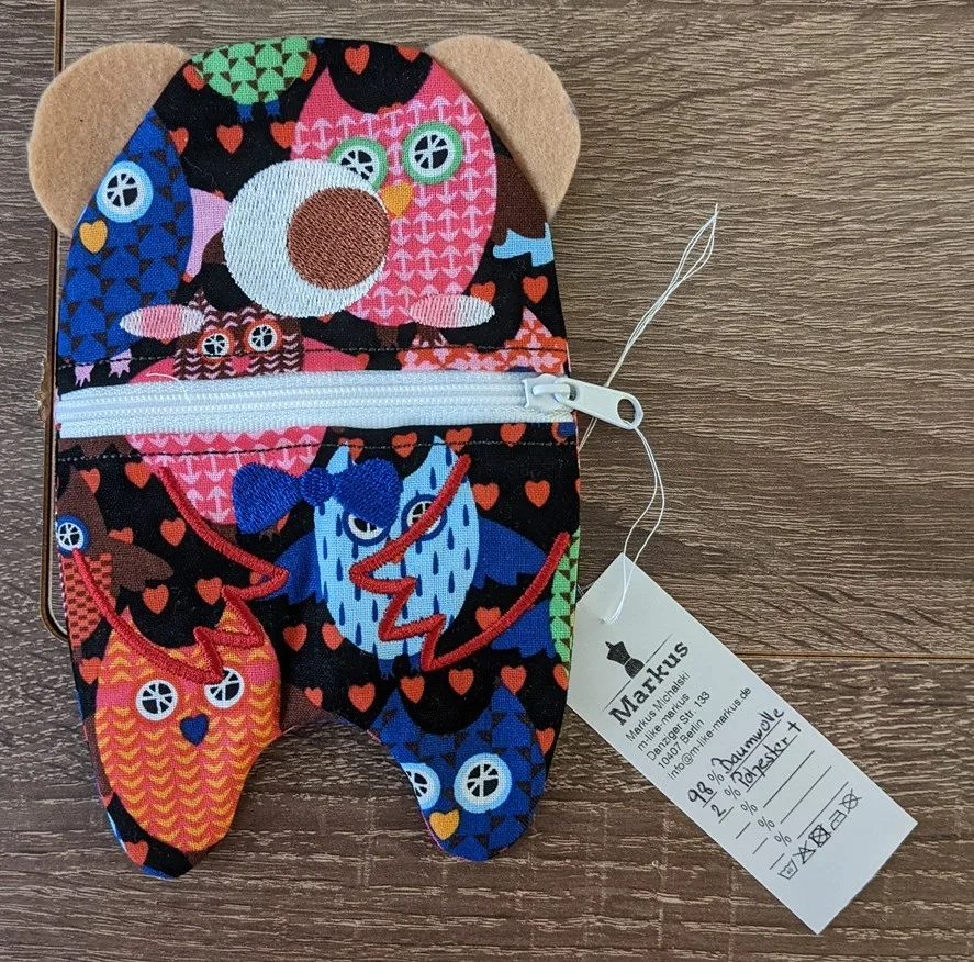 Comfort toy made of fabric with colorful animal figures in red, blue, and orange