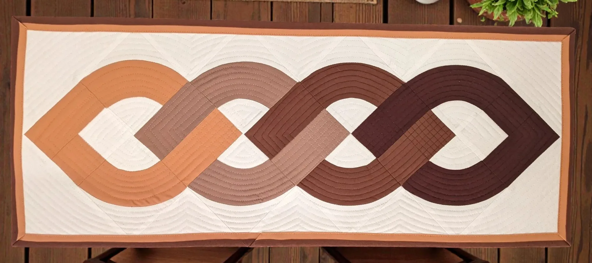 Table runner with a geometric pattern in shades of brown and beige made of cotton